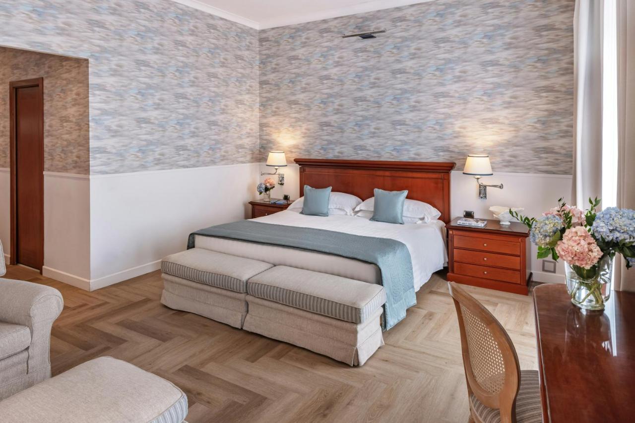 een hotelkamer met een bed en een bank bij Starhotels Terminus in Napels