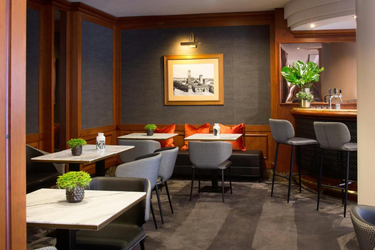 een restaurant met tafels en stoelen en een bar bij Starhotels Tourist in Milaan