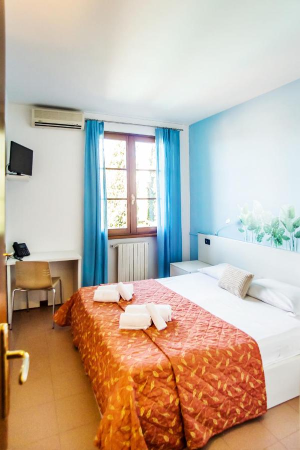 een slaapkamer met een groot bed waarop twee handdoeken liggen bij Hotel Il Castello in Pozzolengo