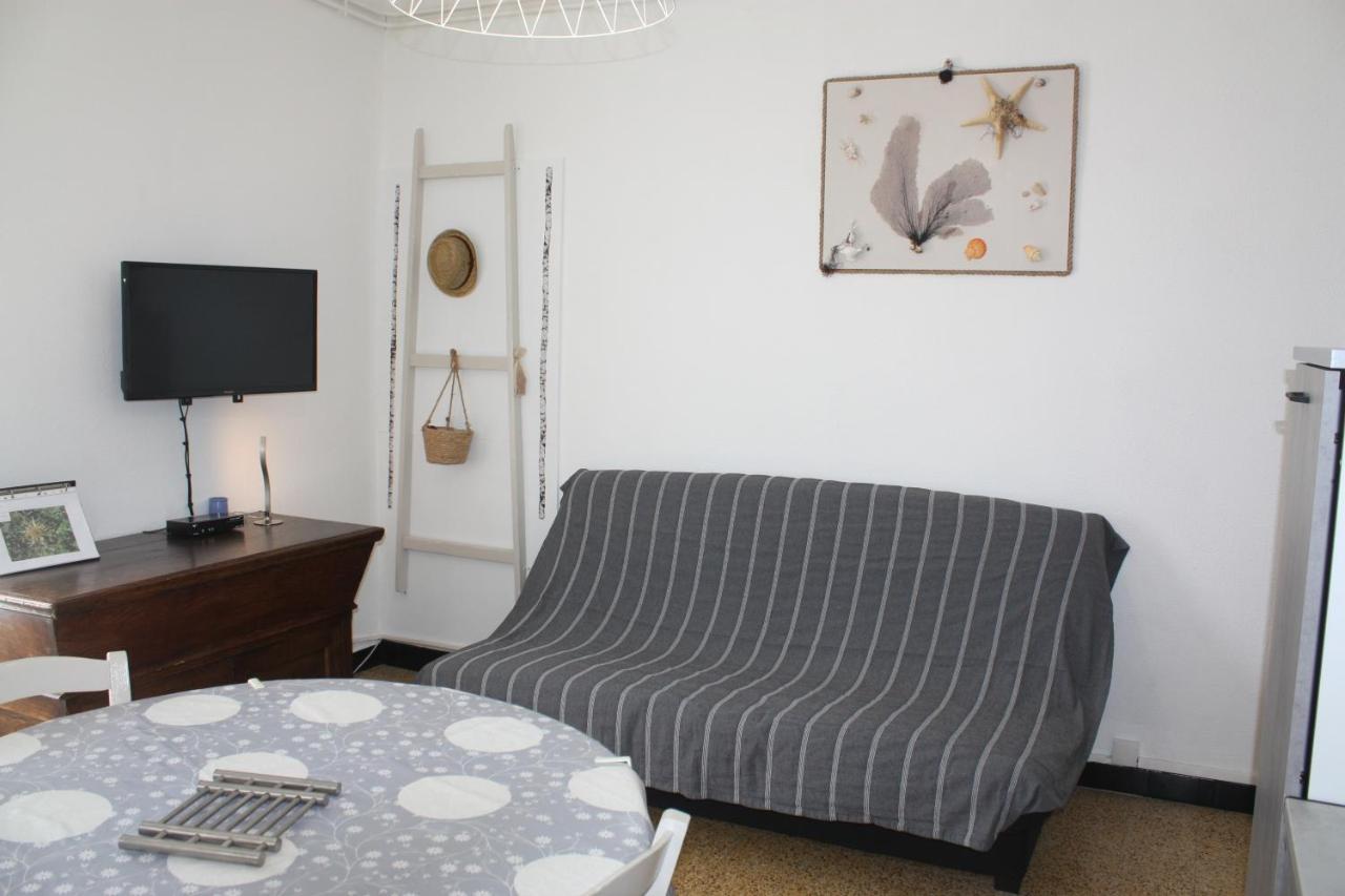 een woonkamer met een bed, een tafel en een televisie bij A CARDICCIA Loc saisonnières PIANA in Piana