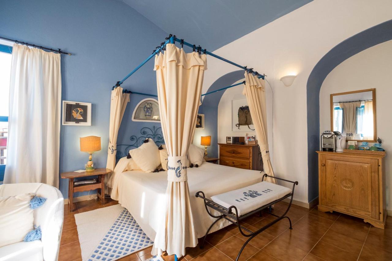 een slaapkamer met een bed met een hemelbed bij Su Gologone Experience Hotel in Oliena