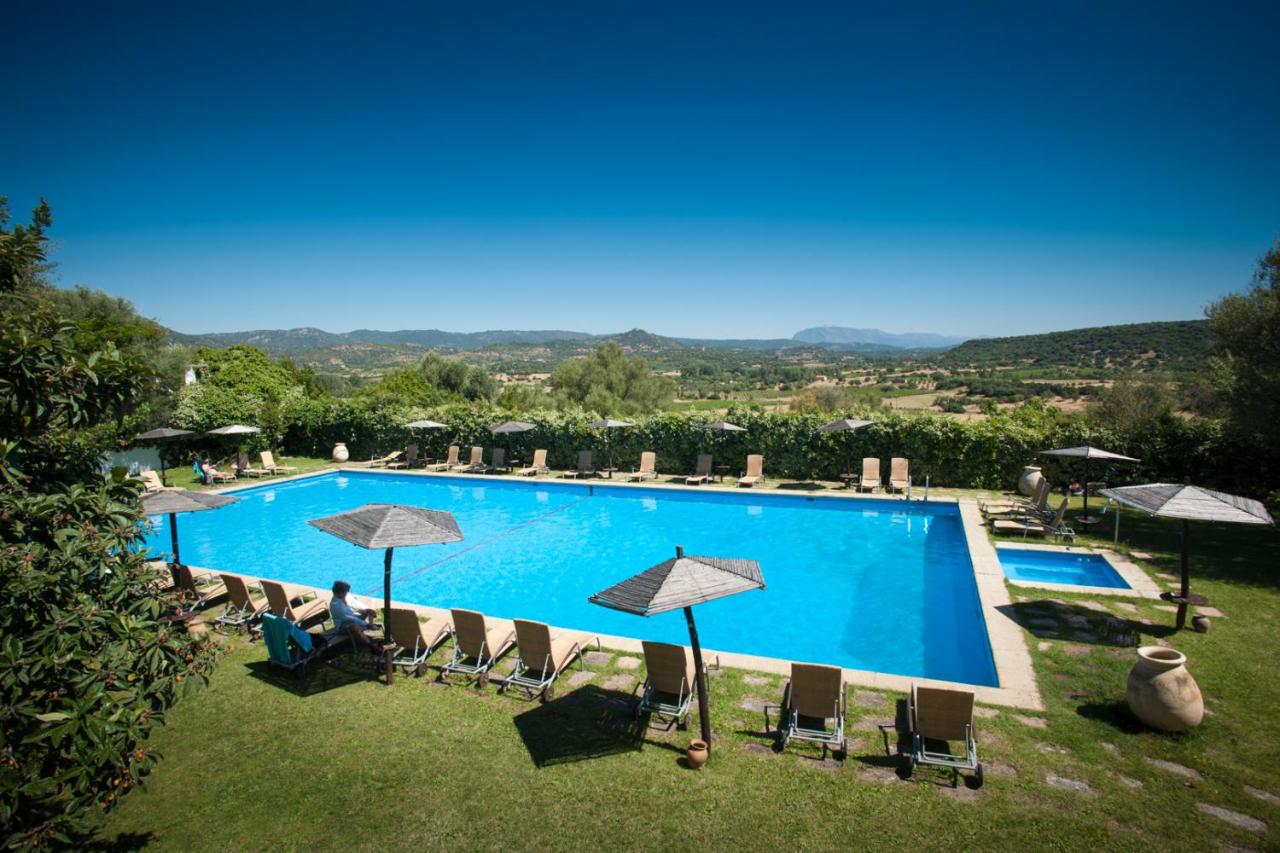 een groot zwembad met ligstoelen en parasols bij Su Gologone Experience Hotel in Oliena +30 foto's