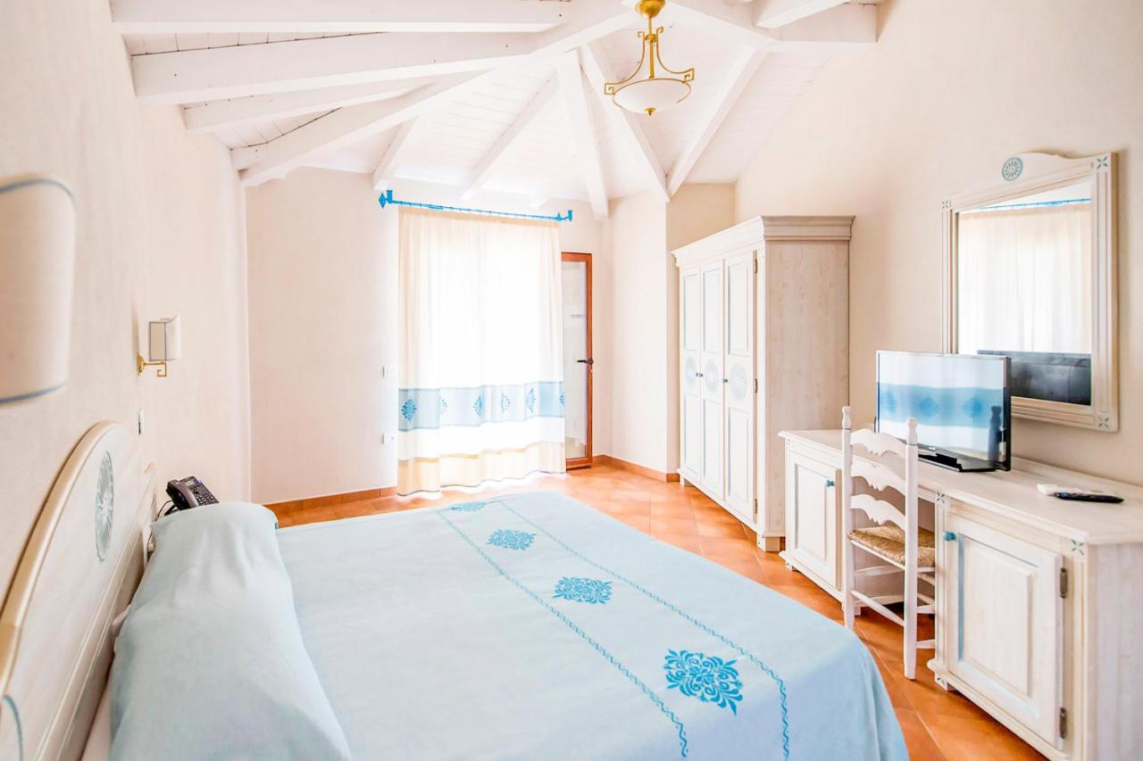 een grote slaapkamer met een bed en een tv bij Marina Torre Navarrese Resort in Santa Maria Navarrese