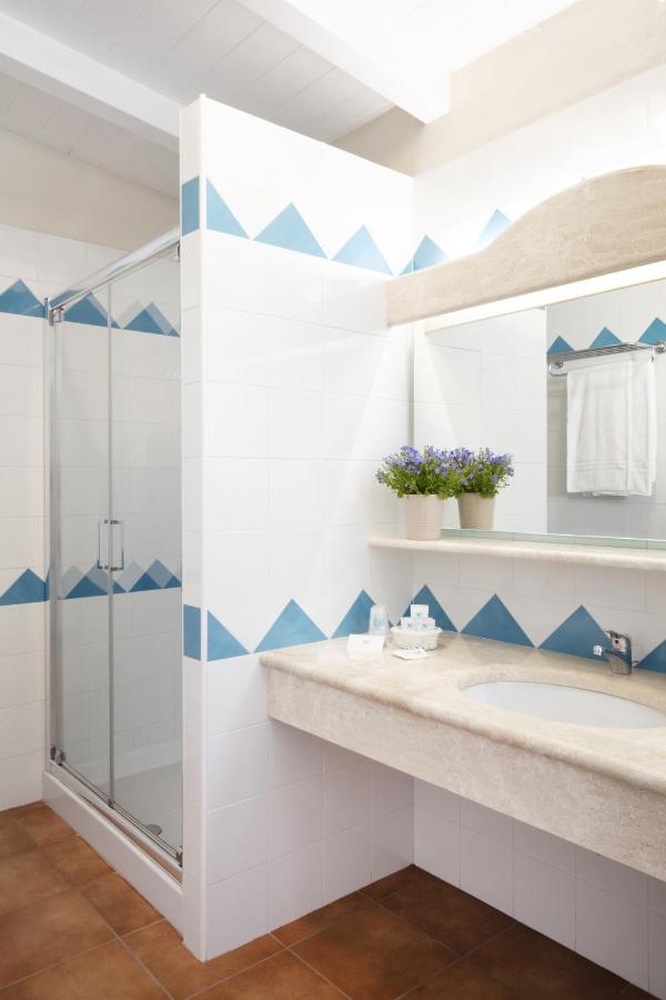 een badkamer met een douche en een wastafel bij Marina Torre Navarrese Resort in Santa Maria Navarrese