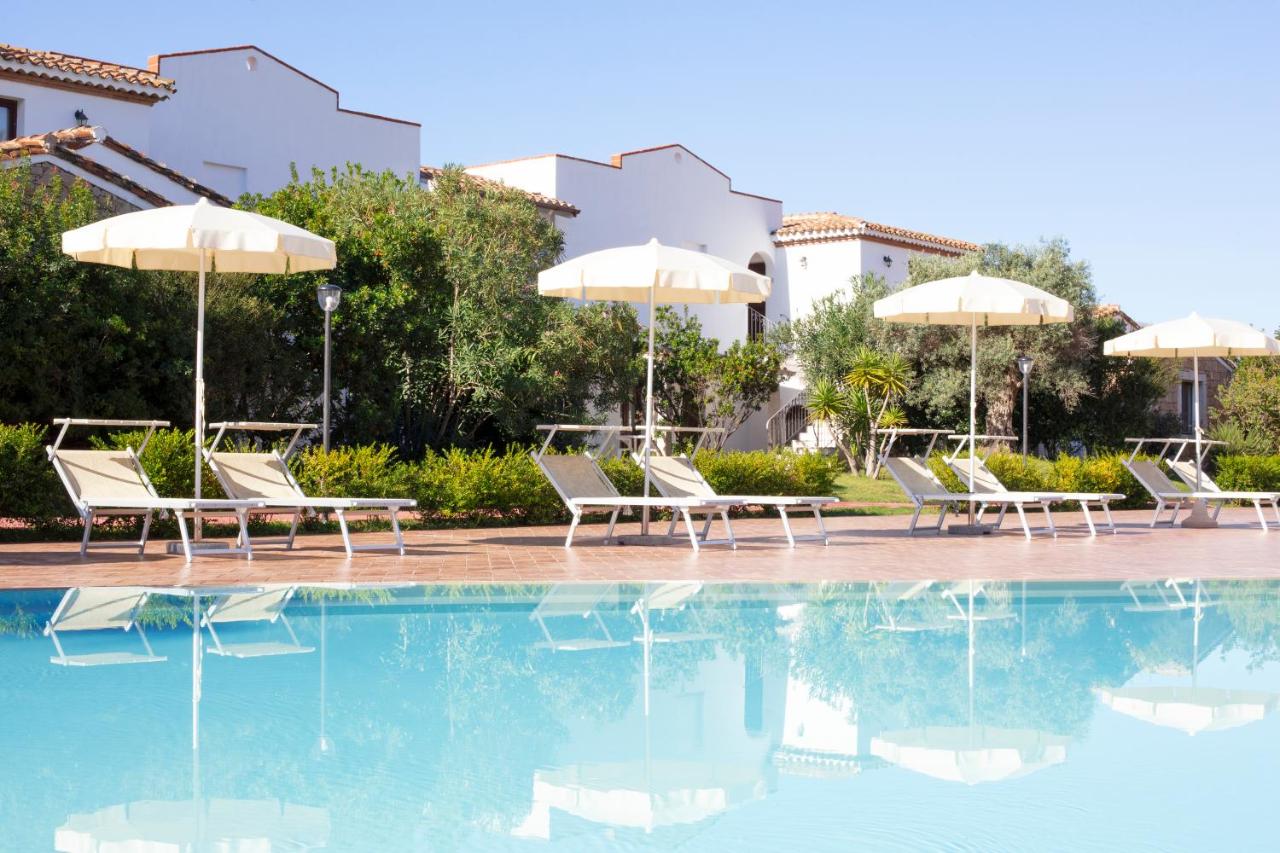 een zwembad met ligstoelen en parasols in een resort bij Marina Torre Navarrese Resort in Santa Maria Navarrese