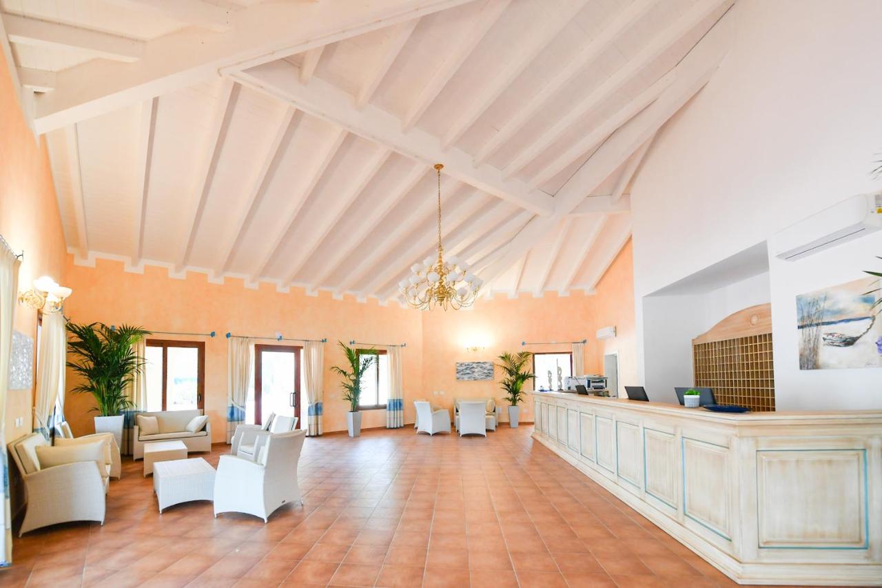 een grote ruimte met een lobby met witte stoelen bij Marina Torre Navarrese Resort in Santa Maria Navarrese +31 foto's