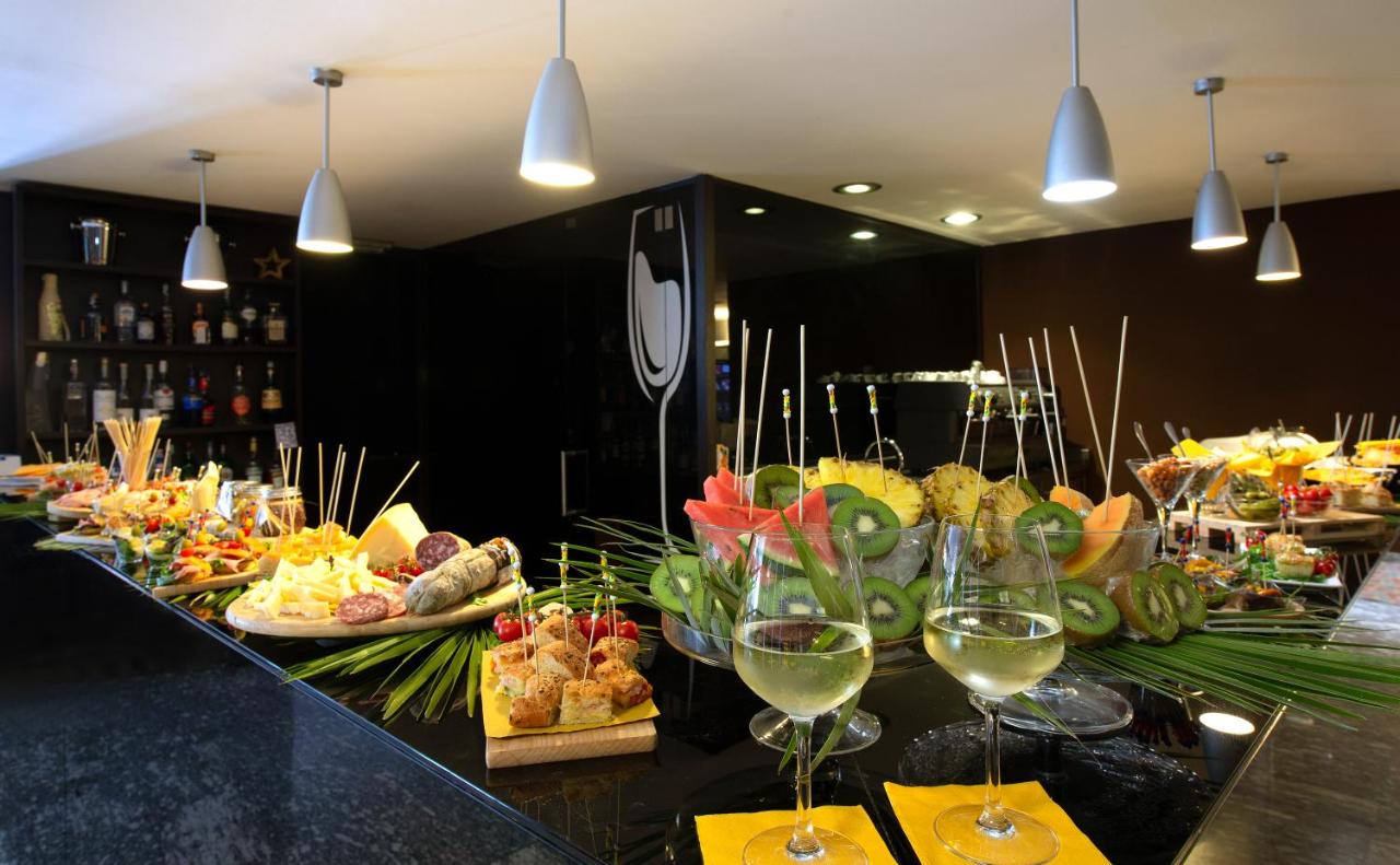een buffet met eten en wijnglazen op een tafel bij Hotel D120 in Olgiate Olona