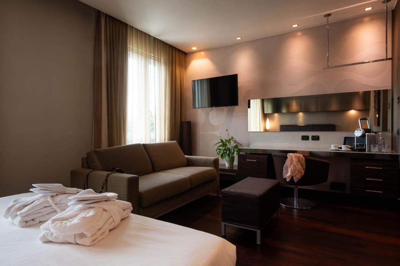 een hotelkamer met een bed, een bank en een bureau bij Axolute Comfort Hotel Como Cantù in Cantù