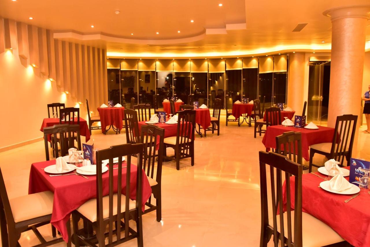 een restaurant met rode tafels en stoelen in een kamer bij Dive Inn Resort in Sharm El Sheikh