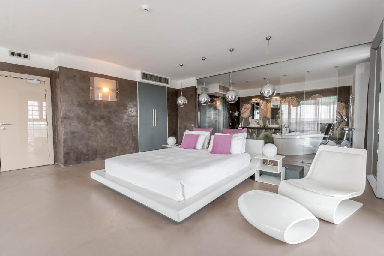een slaapkamer met een groot wit bed en een badkamer bij Hotel For You in Cernusco sul Naviglio