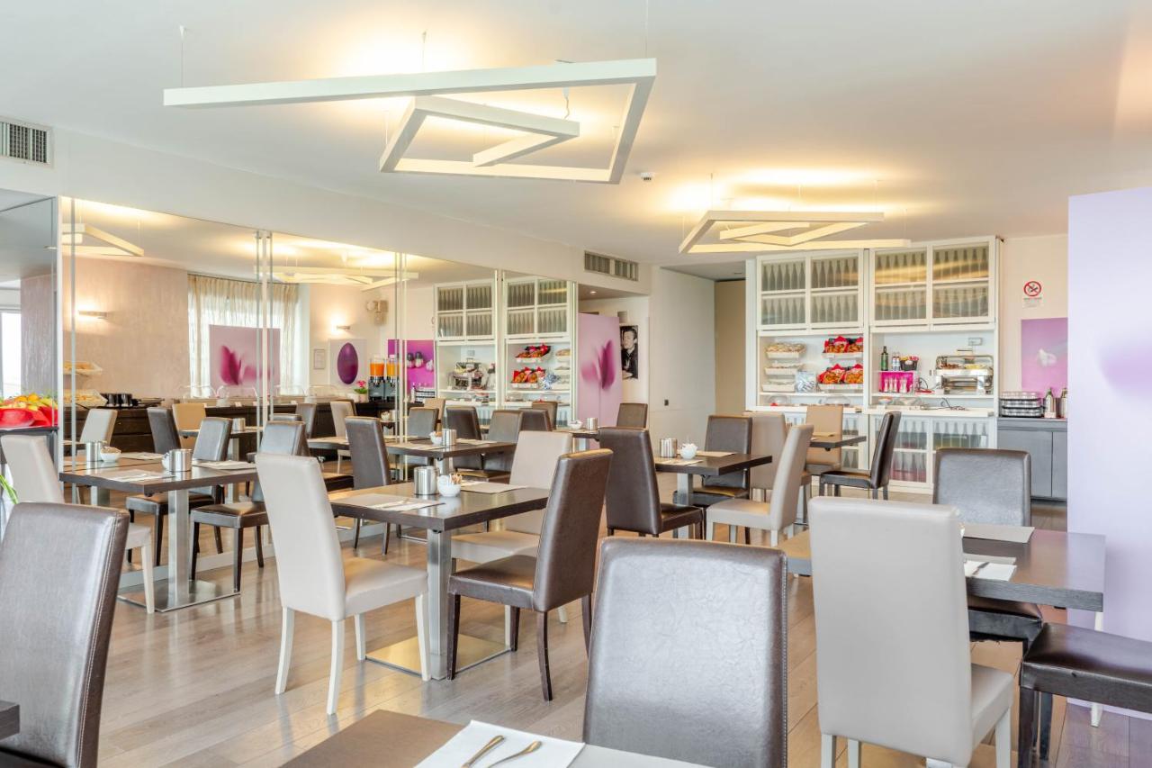 een restaurant met tafels en stoelen in een ruimte bij Hotel For You in Cernusco sul Naviglio