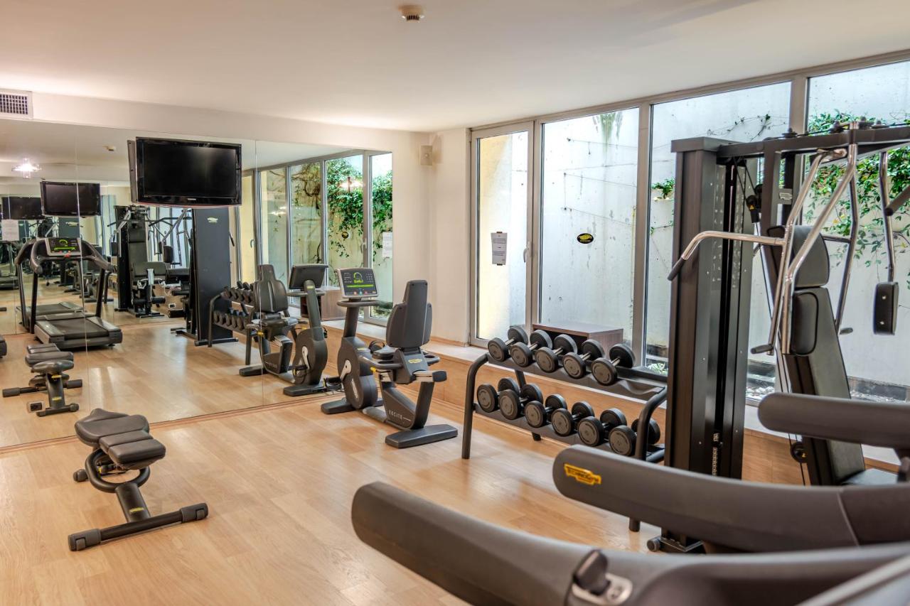 een sportschool met veel loopbanden en gewichten bij Hotel For You in Cernusco sul Naviglio