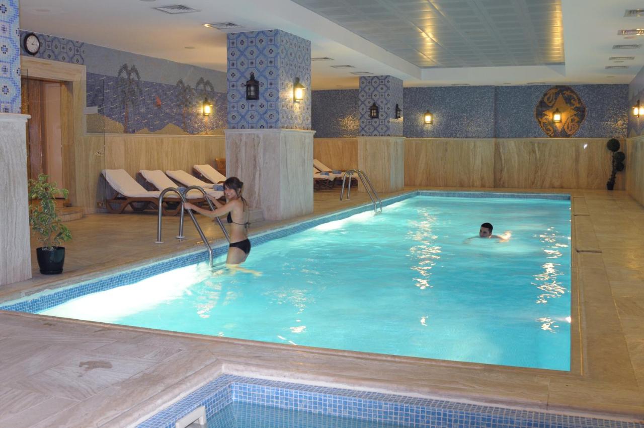 twee personen in een zwembad in een hotel bij Taksim Gonen Hotel in Istanbul