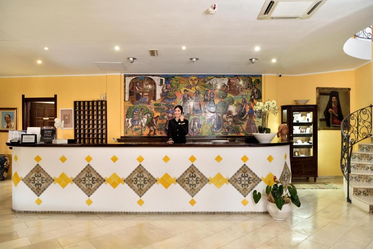een vrouw die achter een toonbank in een winkel staat bij HOTEL ORLANDO Sardegna in Villagrande Strisaili