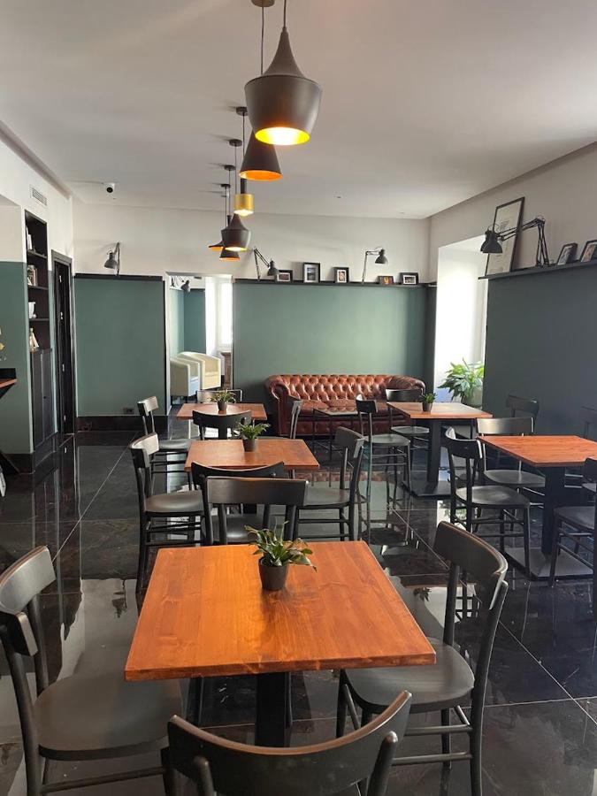 een eetkamer met houten tafels en stoelen bij Hotel Taormina in Rome