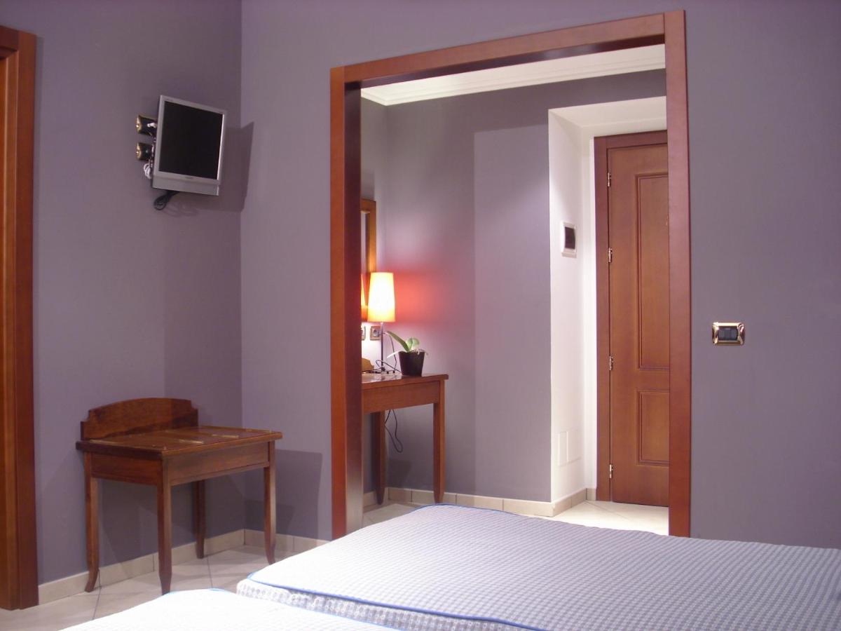 een slaapkamer met een bed, een tafel en een televisie bij Hotel Taormina in Rome +24 foto's