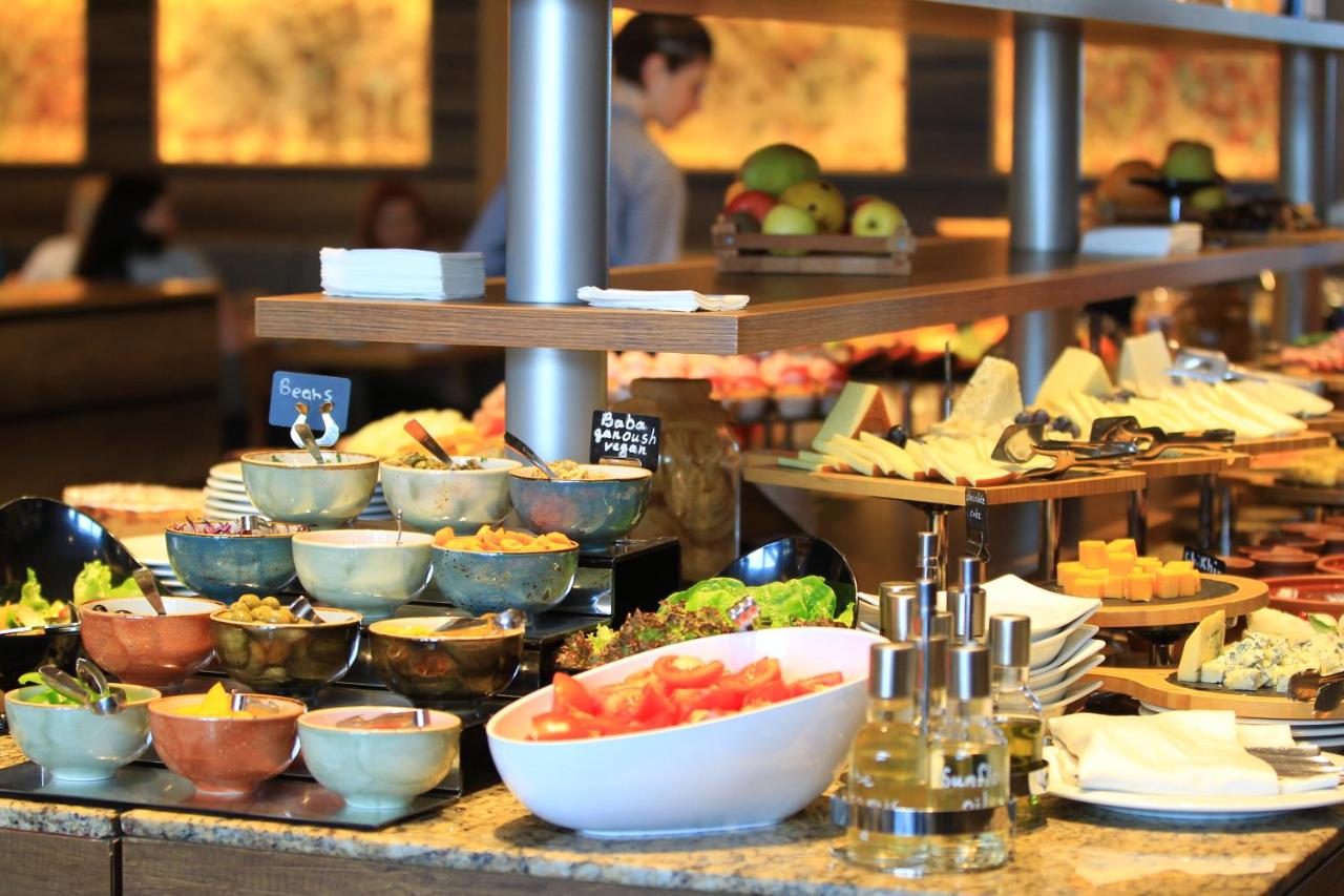 een buffetlijn met borden en schalen vol eten bij Marco Polo Hotel Gudauri in Goedaoeri
