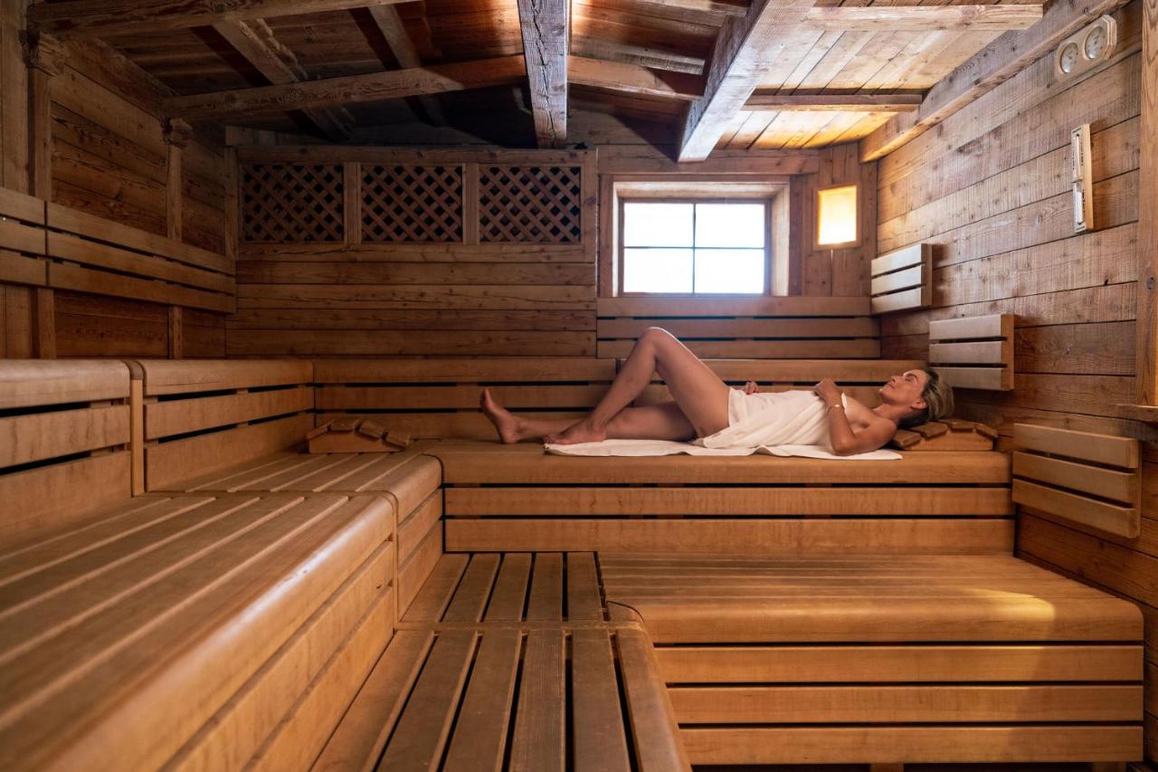 een vrouw die in een sauna ligt bij Tevini Dolomites Charming Hotel in Commezzadura