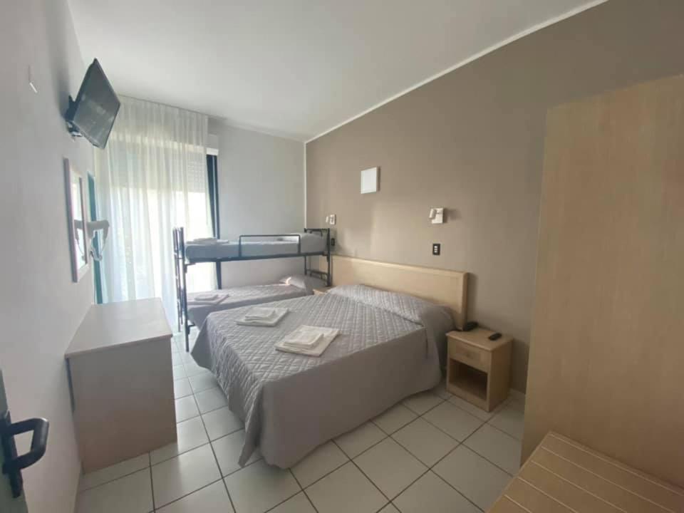 een kleine slaapkamer met een bed en een raam bij Hotel Rex in Lido di Savio