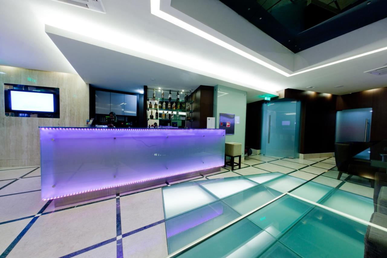 een lobby met een paarse bank en een bar bij TURIM Luxe Hotel in Lissabon