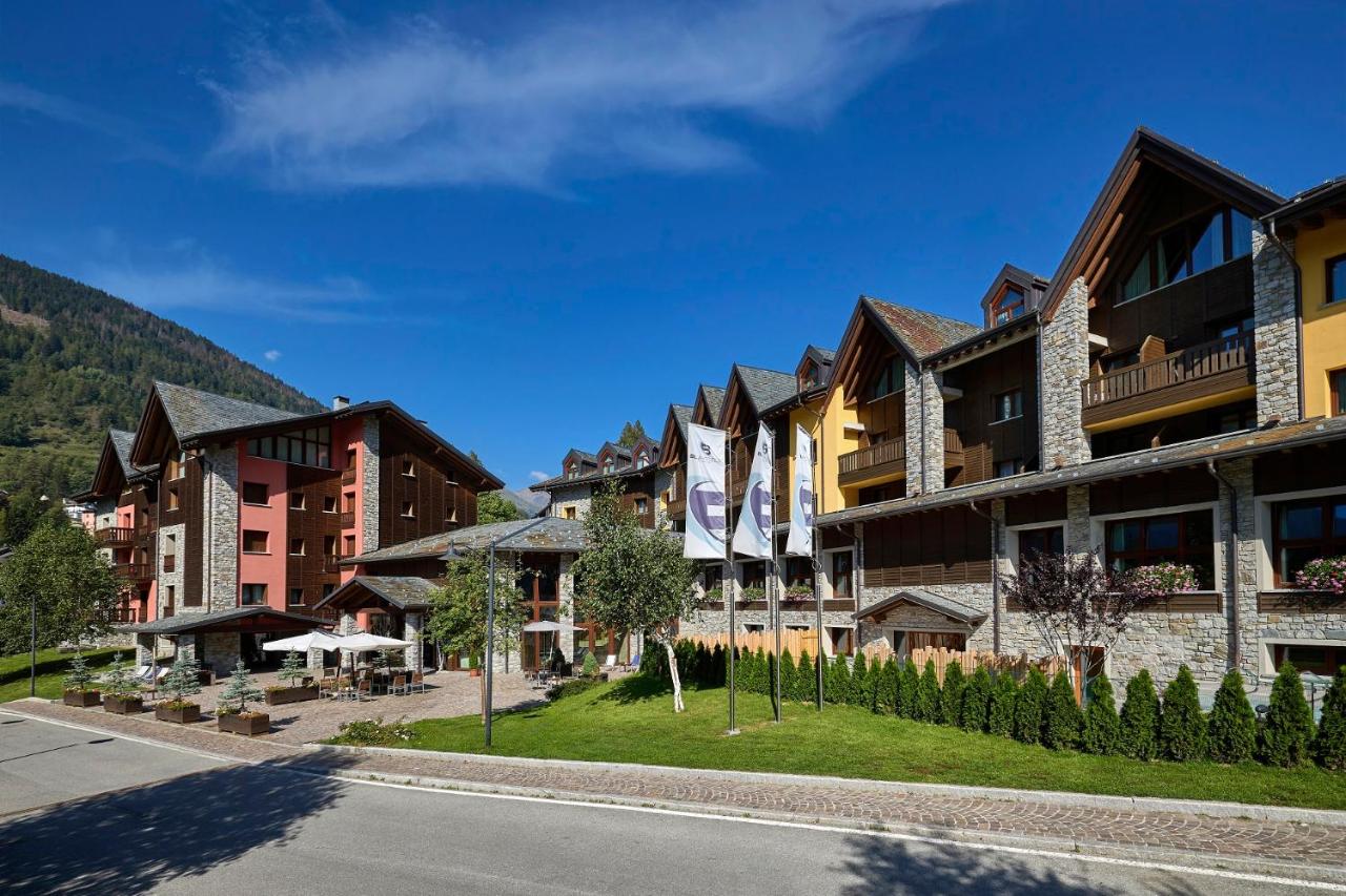 een rij gebouwen in een straat naast een berg bij Blu Hotel Acquaseria in Ponte di Legno