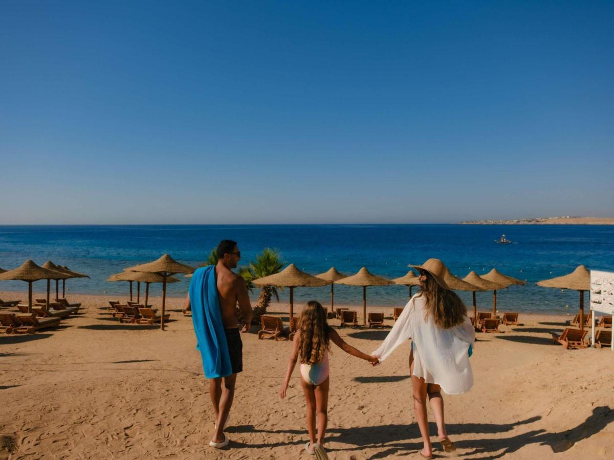 een gezin dat op het strand wandelt bij Movenpick Resort Sharm El Sheikh in Sharm El Sheikh