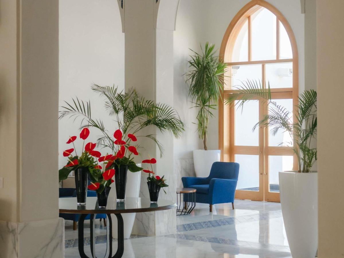 een kamer met een tafel met bloemen en een raam bij Movenpick Resort Sharm El Sheikh in Sharm El Sheikh