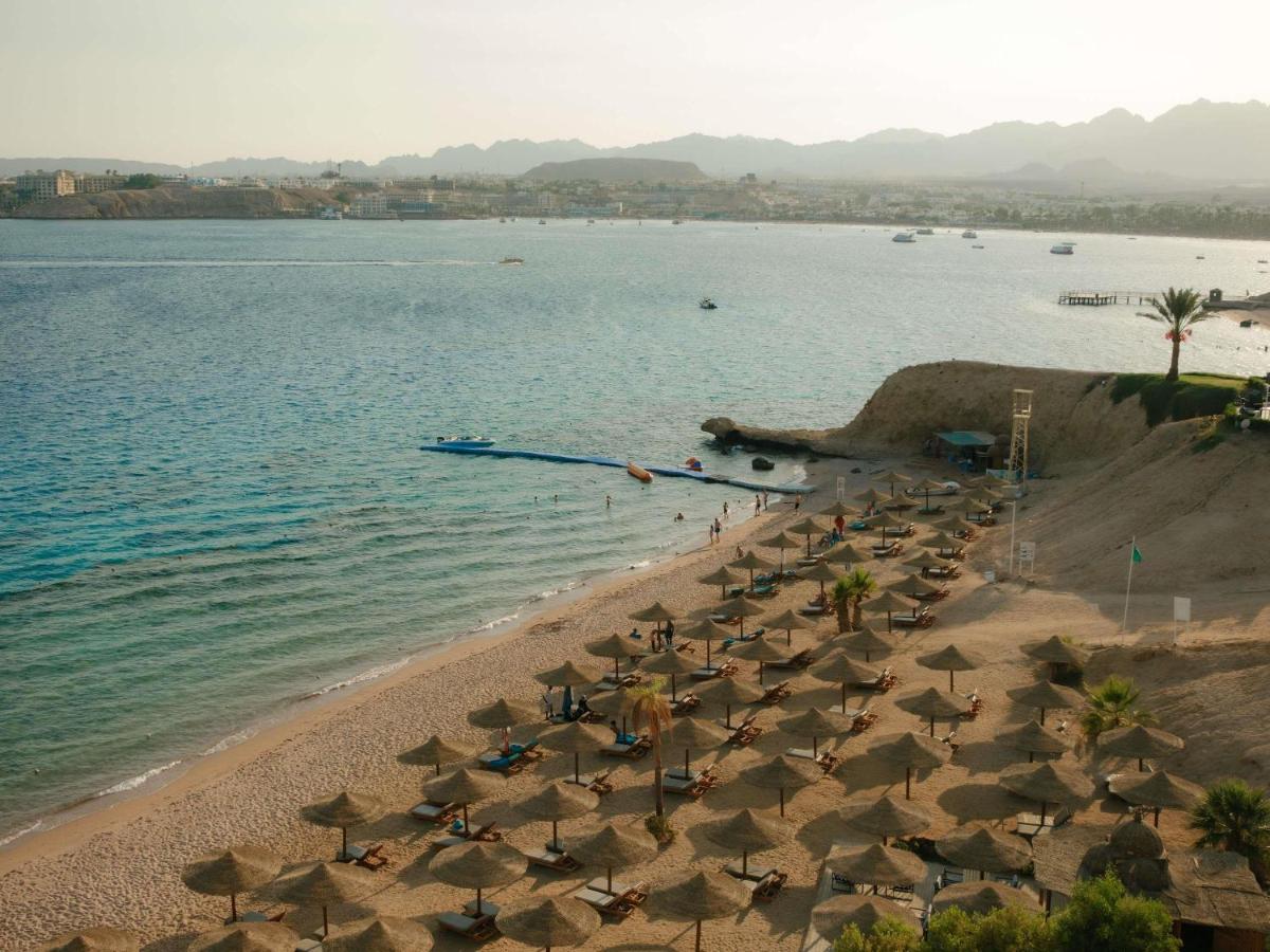 Een luchtfoto van een strand met stoelen en parasols. bij Movenpick Resort Sharm El Sheikh in Sharm El Sheikh