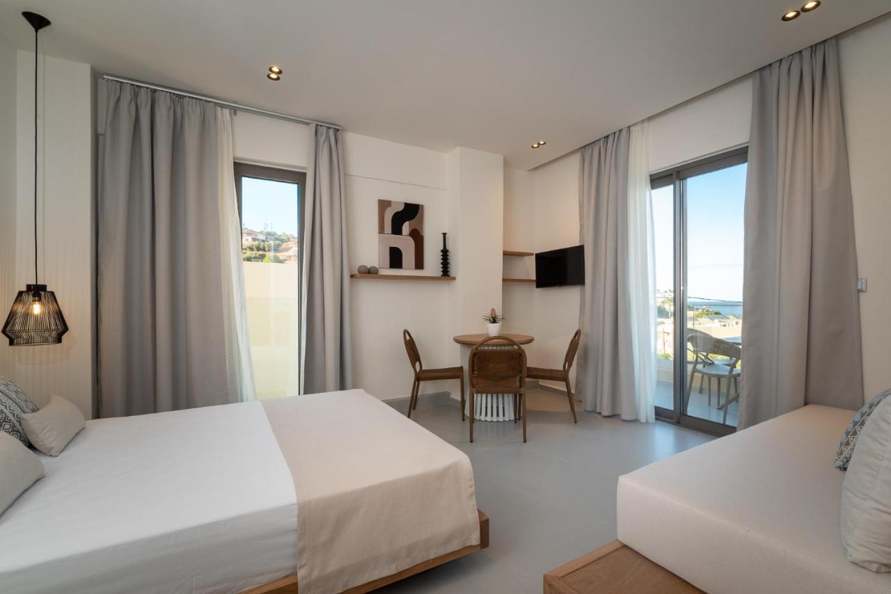 een hotelkamer met twee bedden en een tafel en stoelen bij Elpis Studio Apartments in Balíon +112 foto's