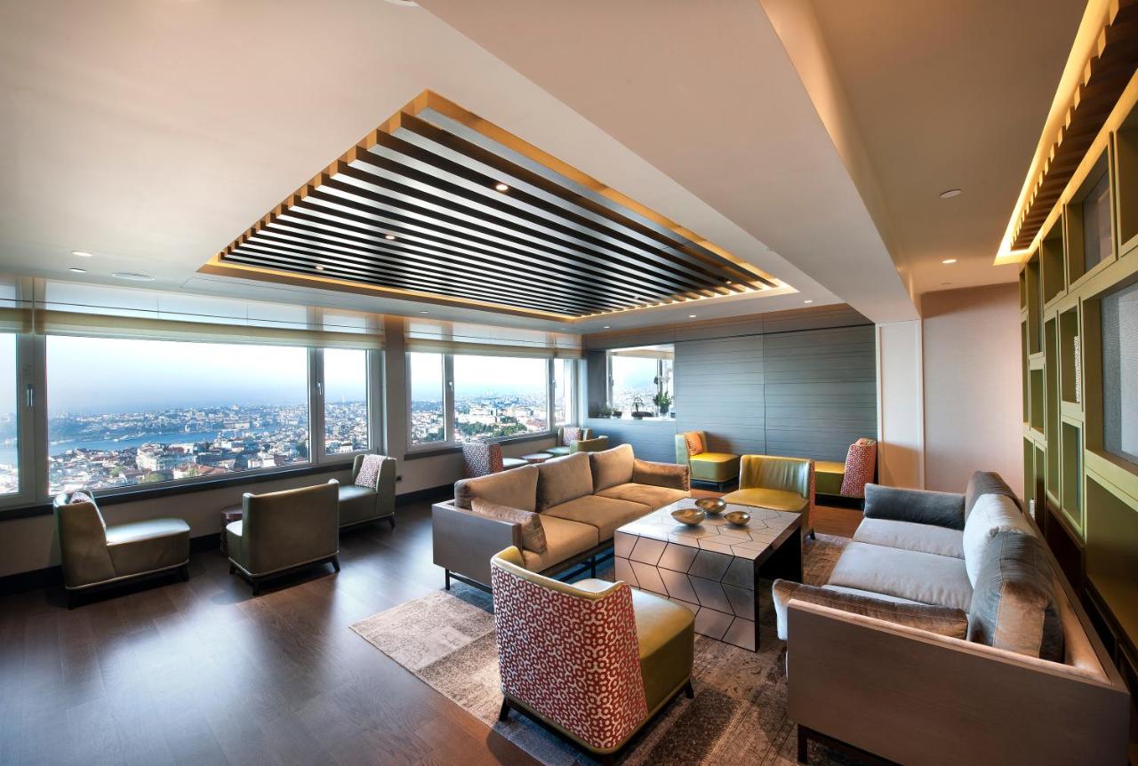 een woonkamer met banken en uitzicht op een stad bij The Marmara Taksim in Istanbul