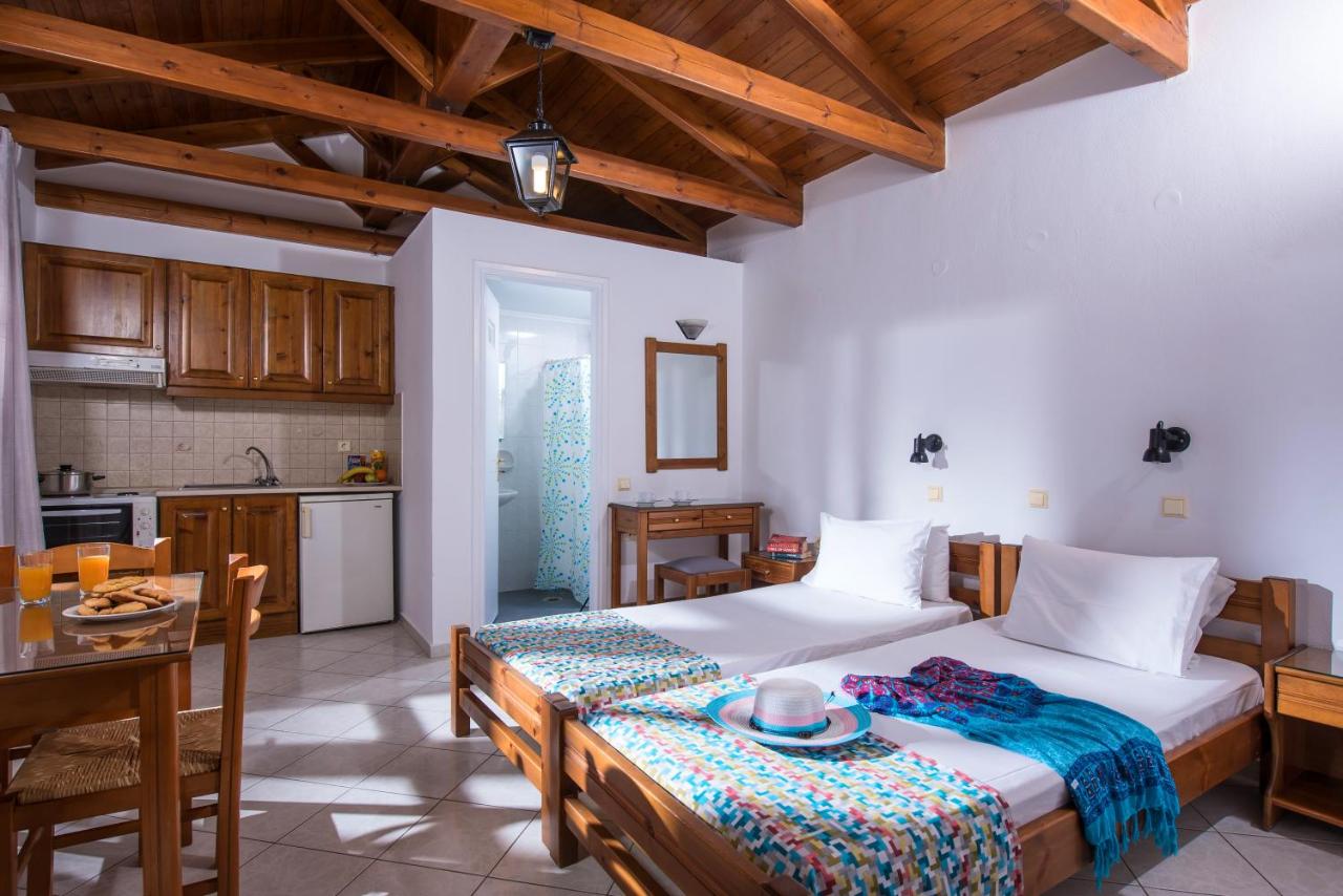 een slaapkamer met een groot bed en een keuken bij Rena Apartments in Gouves