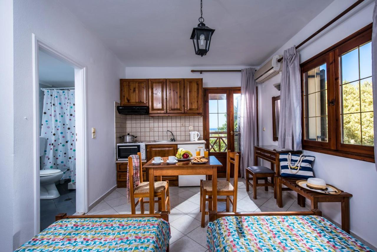 een keuken en eetkamer met een tafel en stoelen bij Rena Apartments in Gouves