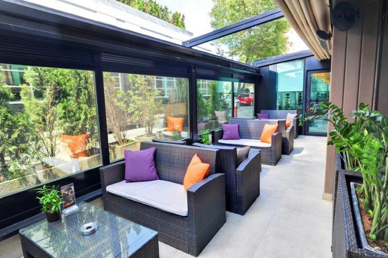een buitenterras met stoelen en tafels en ramen bij Avantgarde Urban Levent in Istanbul