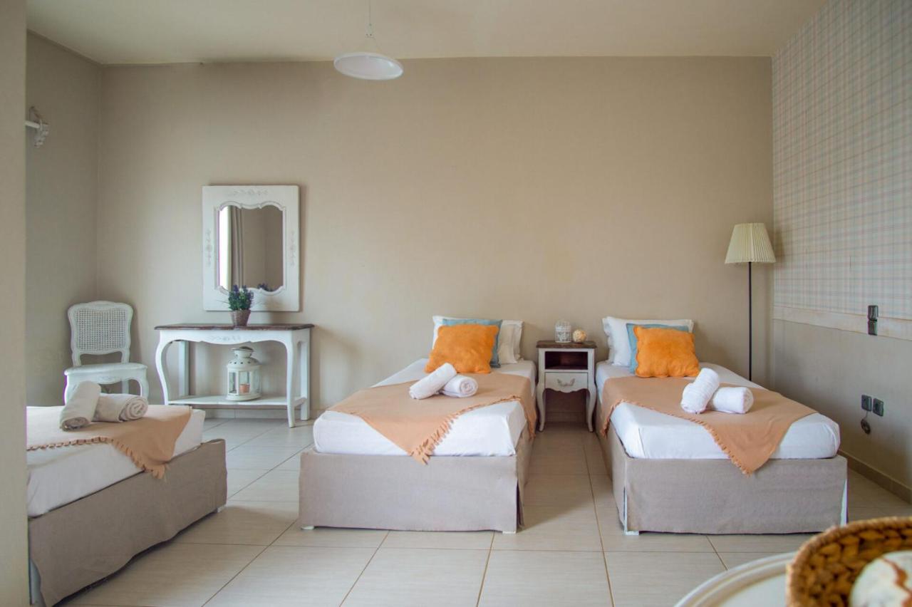 een woonkamer met twee bedden en een spiegel bij Golden Sun Boutique in Malia