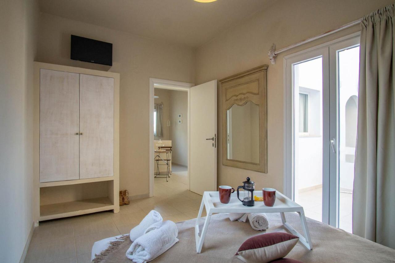 een kamer met een bed, een tafel en een spiegel bij Golden Sun Boutique in Malia