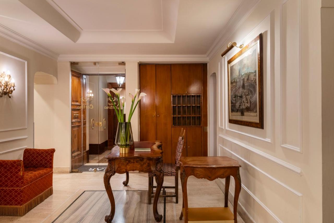een hal met een tafel en een vaas met bloemen bij Hotel Cortina in Rome