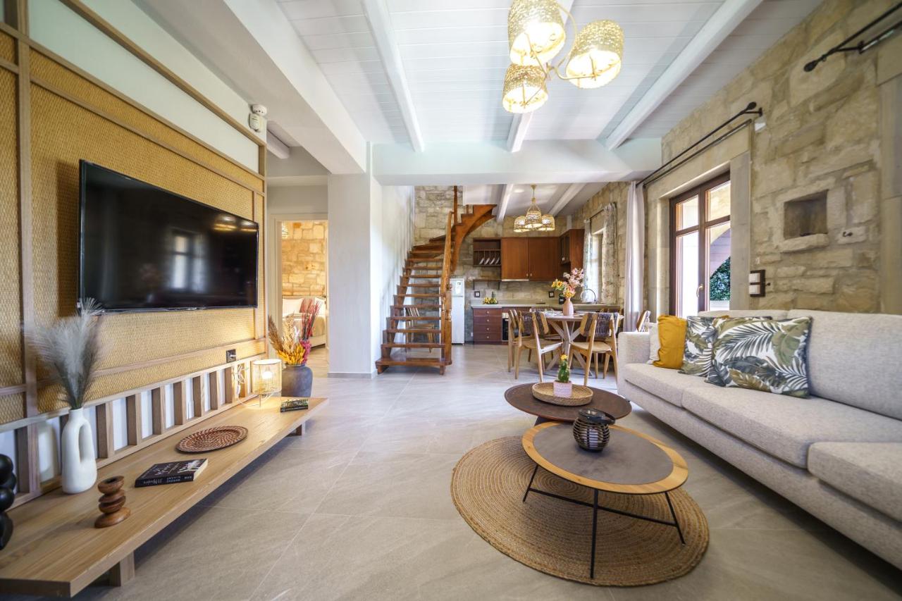 een woonkamer met een bank en een tv bij Asion Lithos Villas & Suites with Private Pools in Kato Asites