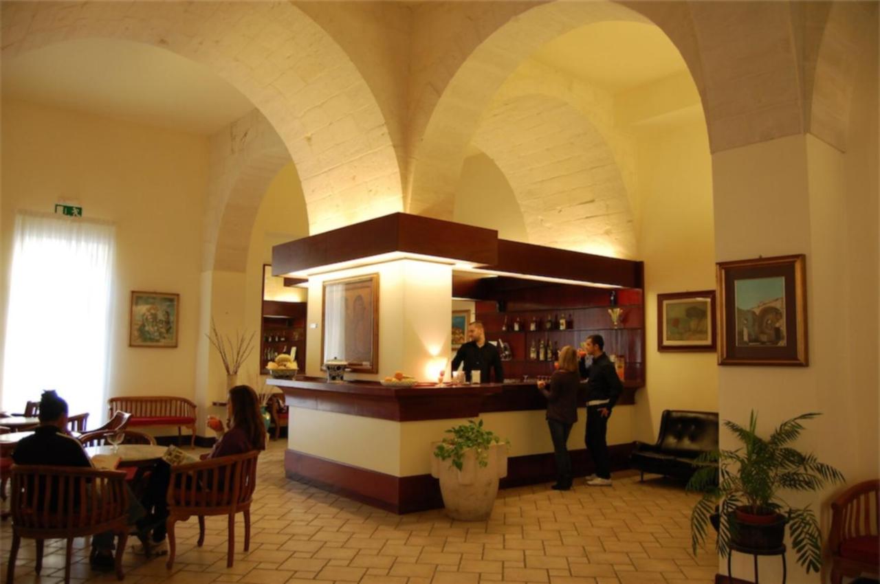 een groep mensen die rond een bar in een restaurant staan bij Hotel Miramare in Otranto