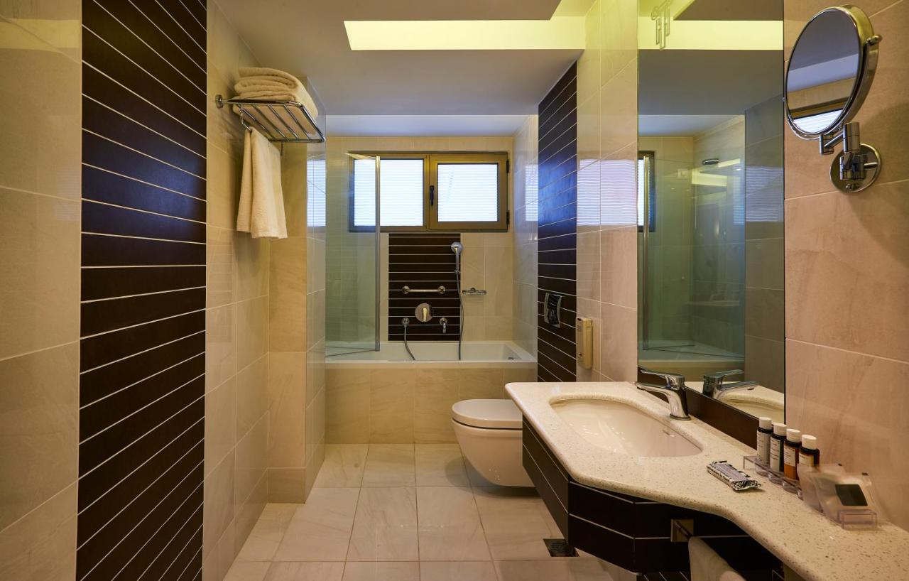 een badkamer met een toilet, een wastafel en een badkuip bij Titania Hotel in Athene