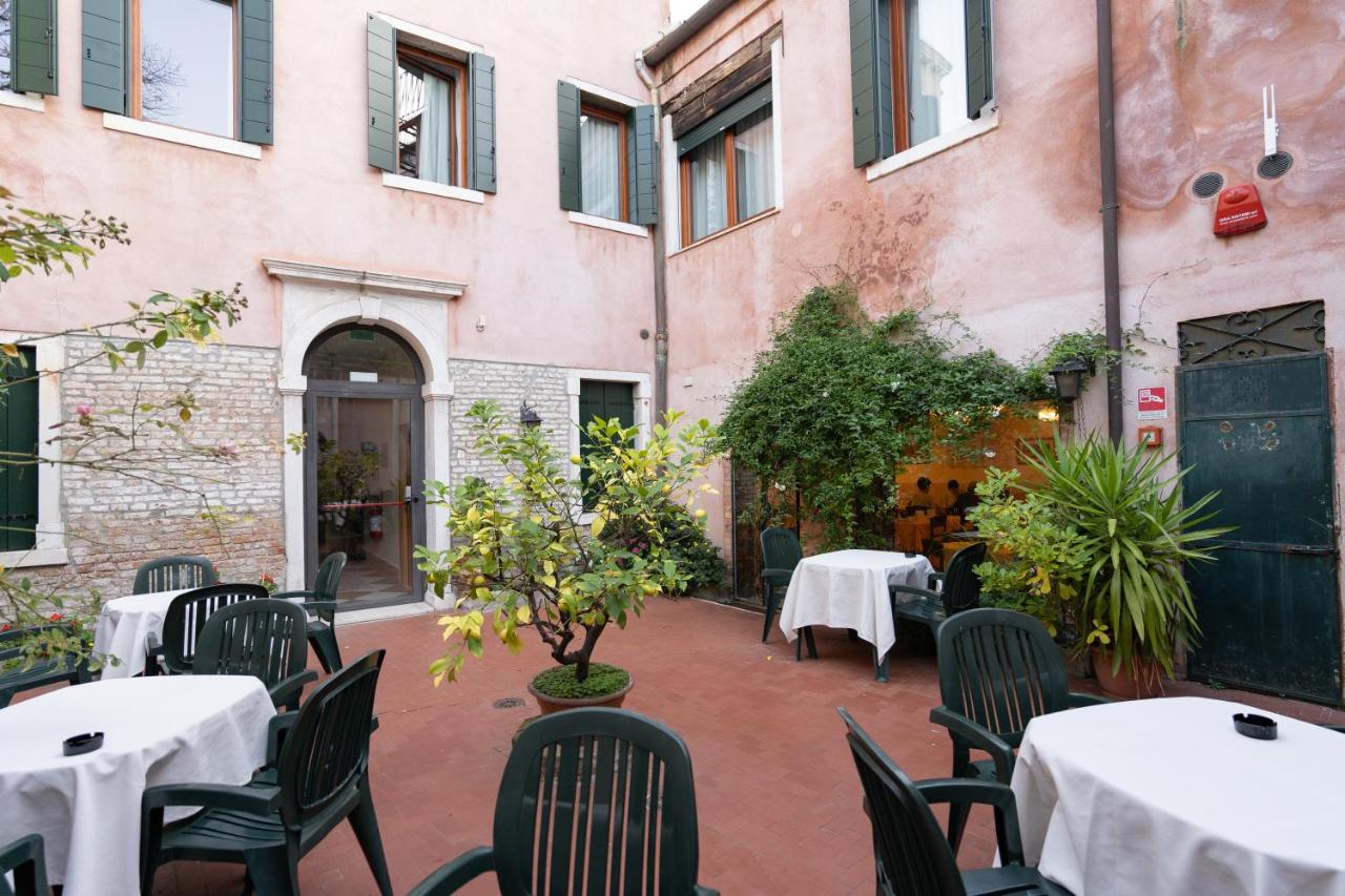 een buitenterras met tafels en stoelen bij een restaurant bij Hotel Tivoli in Venetië