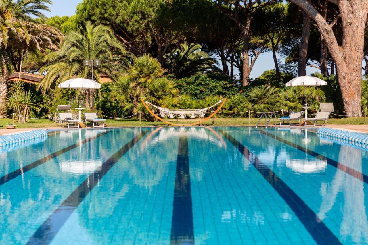 een zwembad met een hangmat en palmbomen bij Gitavillage Argentario in Albinia