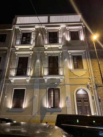 een wit gebouw met ramen aan een straat 's nachts bij Al Castello Luxury B&B in Reggio di Calabria +34 foto's