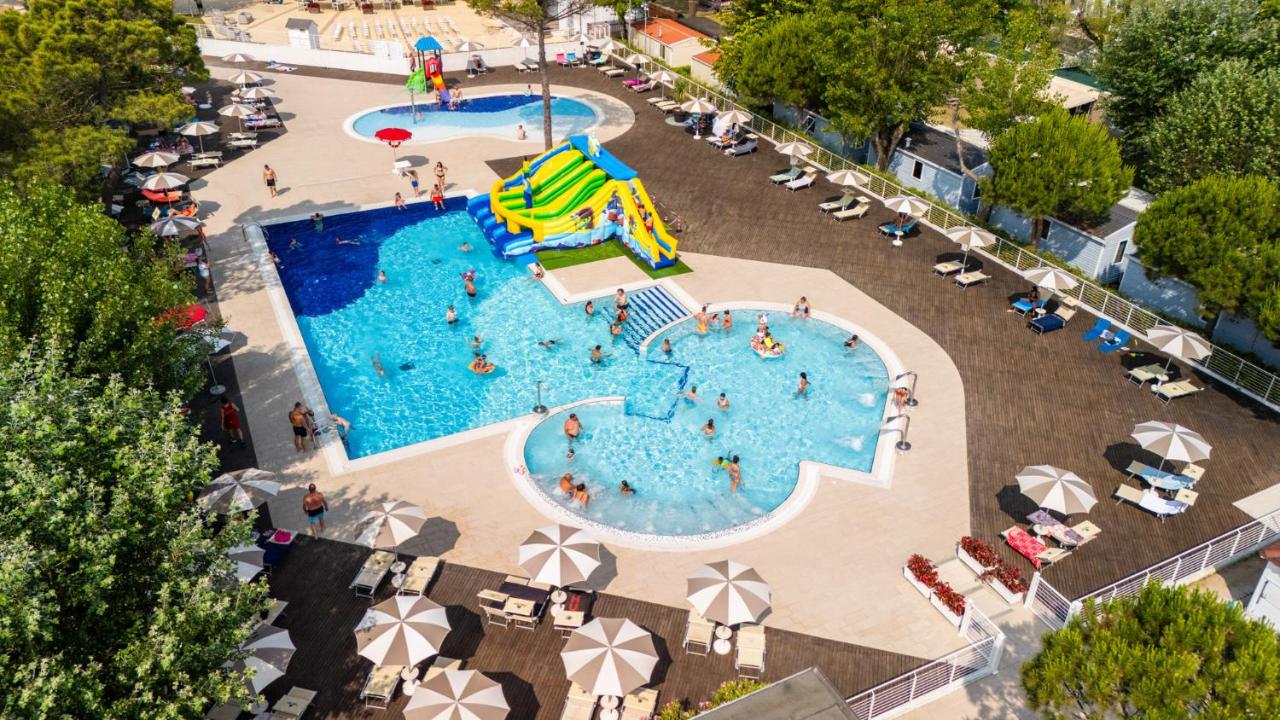 Een bovenaanzicht van een zwembad met een glijbaan. bij Club del Sole Marina Family Resort in Punta Marina