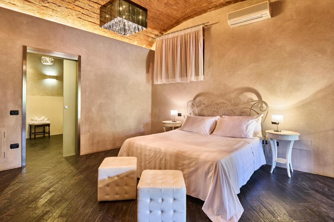 een slaapkamer met een groot bed met een witte sprei bij Borgo San Giusto in Empoli