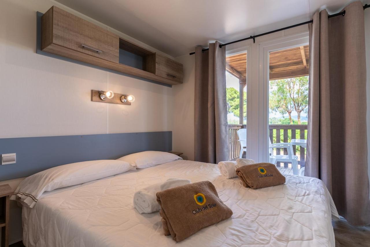 een slaapkamer met een bed waarop twee kussens liggen bij Club del Sole Orbetello Family Collection in Orbetello