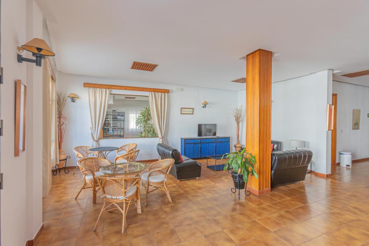 een woonkamer met een tafel en stoelen bij Hotel Tres Jotas Conil in Conil de la Frontera