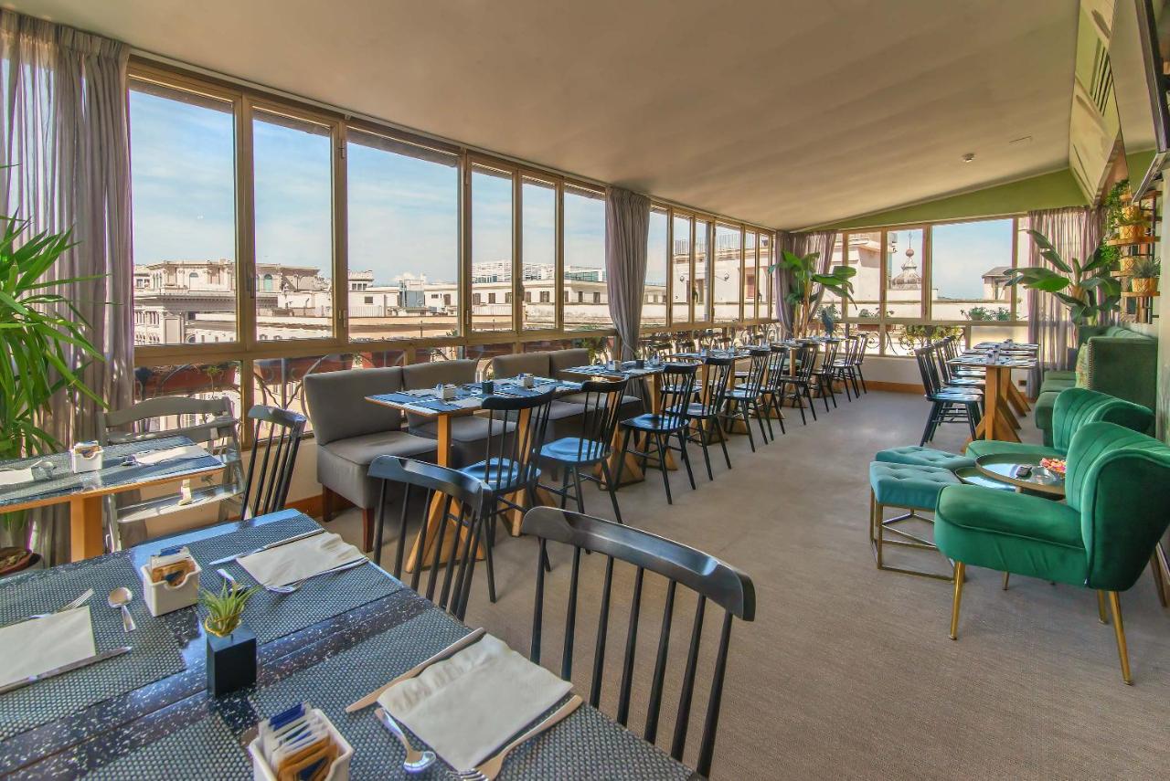een restaurant met tafels, stoelen en ramen bij Hotel Tritone in Rome