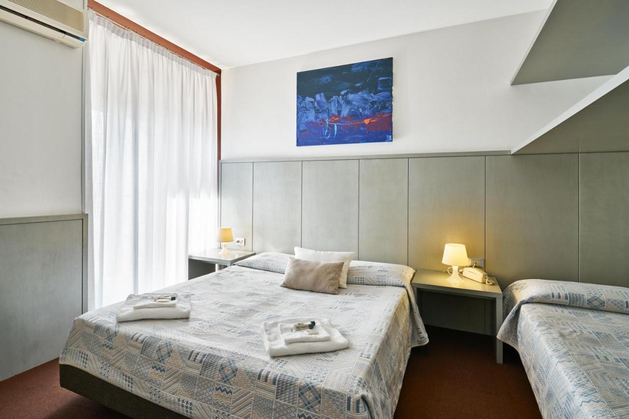 een hotelkamer met twee bedden en handdoeken erop. bij Hotel Europa in Grado
