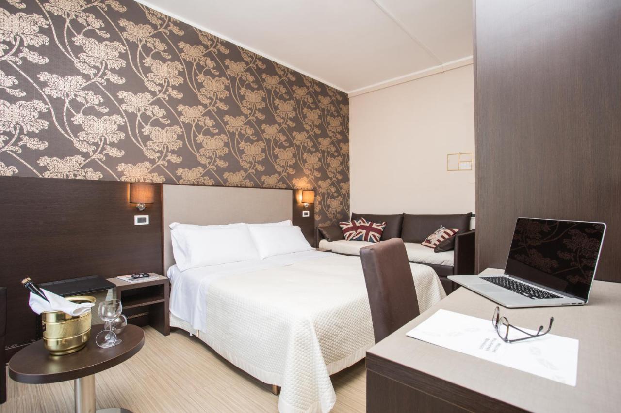 een hotelkamer met een bed en een laptop op een bureau bij Hotel Lalla Beauty & Relax in Cesenatico