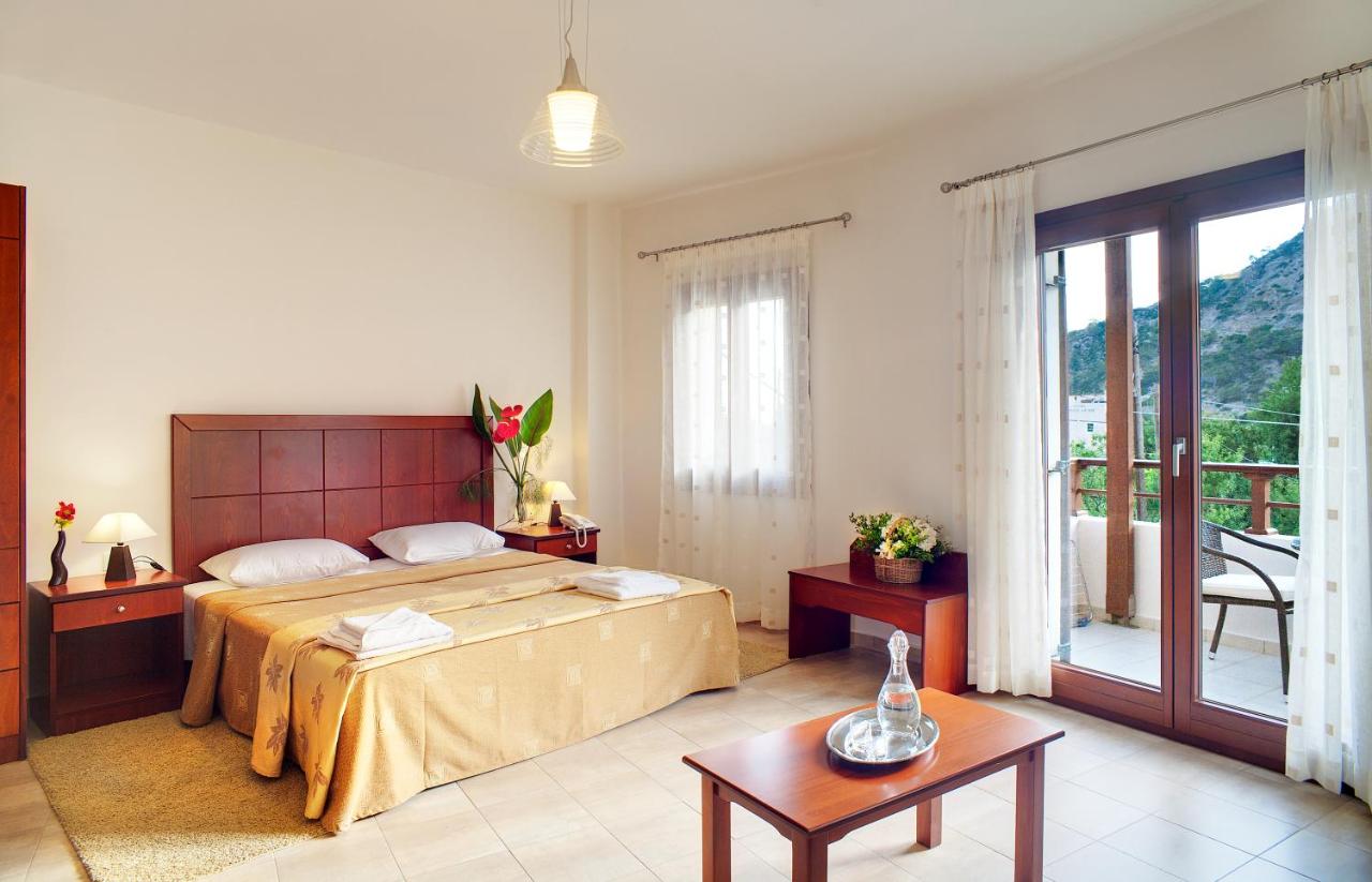 een slaapkamer met een groot bed en een balkon bij Syia Hotel in Sougia